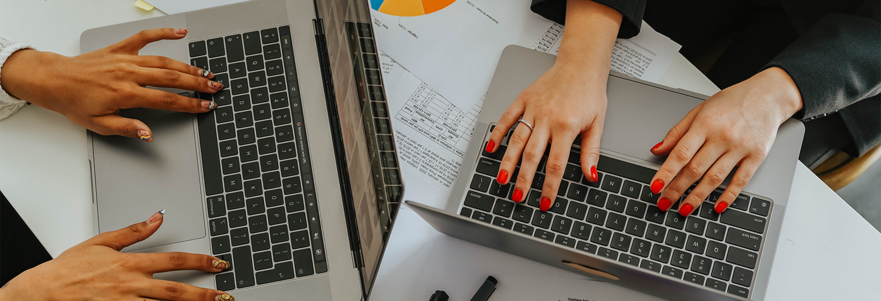 Two people typing on computers